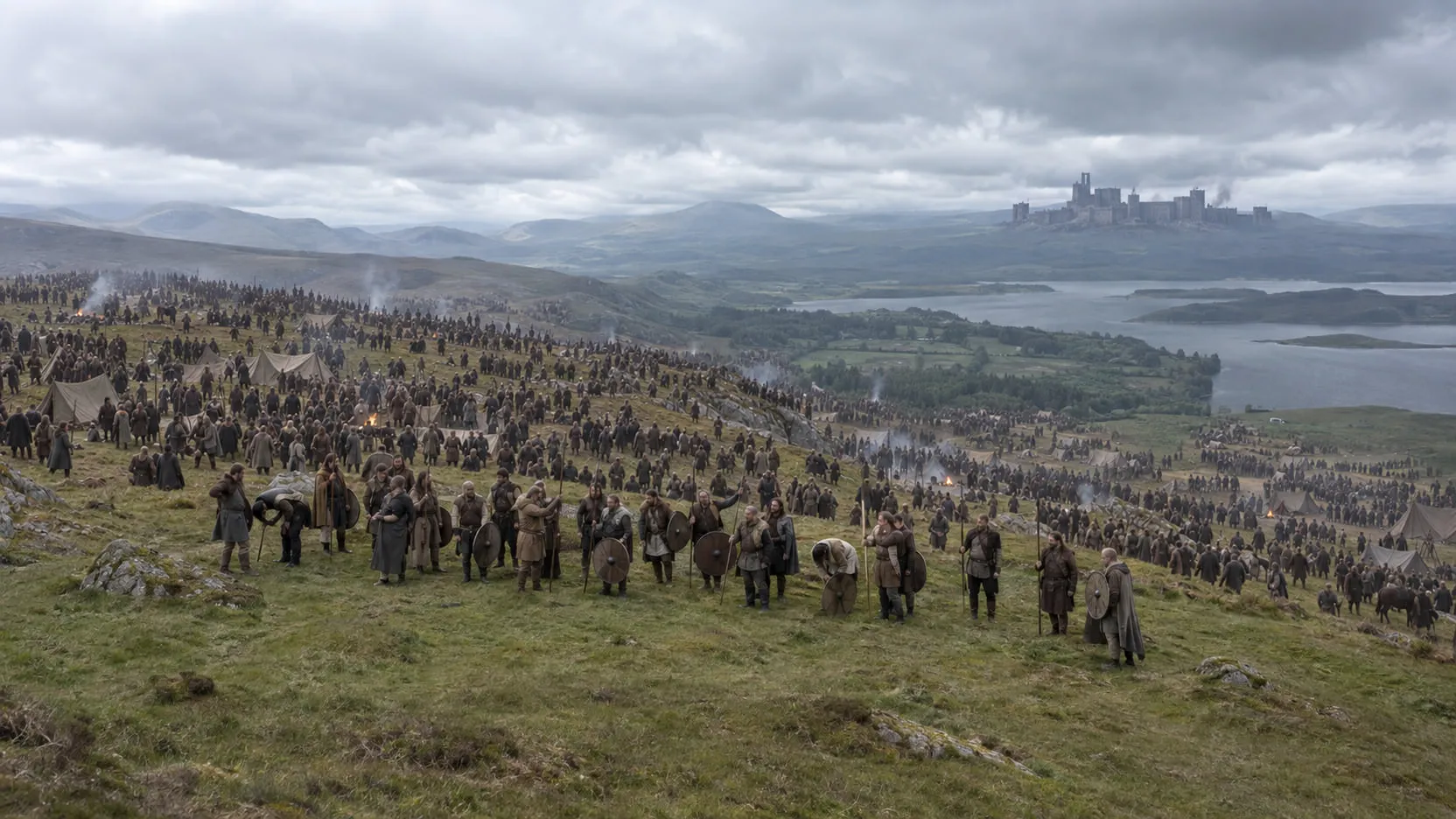 Finished shot: the same extras in front of an army of thousands filling the hillside and valley, a stone fortress on the far ridge.